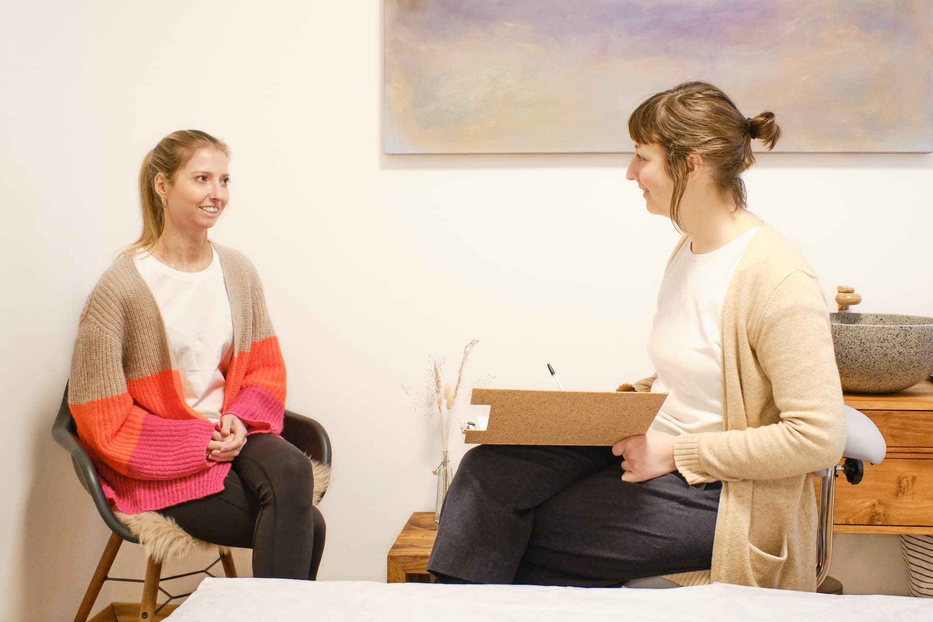 Ein Foto einer Beratung. Paula Dauben­büchel sitzt mit einer Patientin im Behandlungszimmer.
